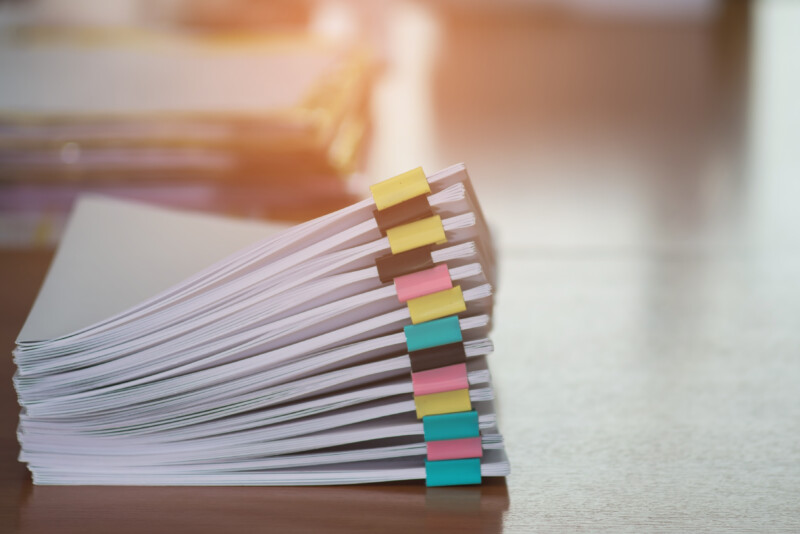 Paper,Documents,Stacked,On,Wooden,Desk,At,Workplace.business,Concept.